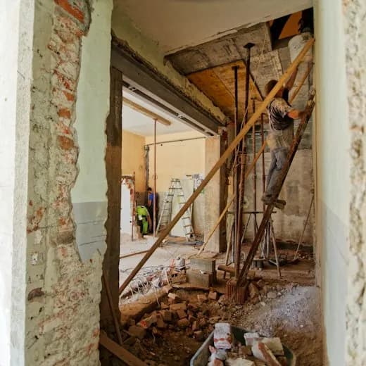 Un ouvrier sur une échelle en plein chantier