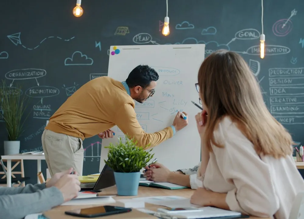 Un formateur écrit au tableau devant un groupe
