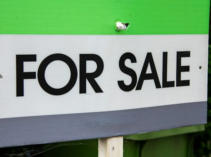 Un panneau de vente devant une maison